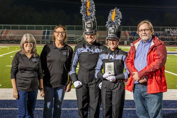 Nolensville High band members smile on the side of the field